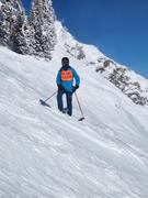 Derek standing on a steep run at Aspin highlands, Colorado, with cliffs and trees in the background